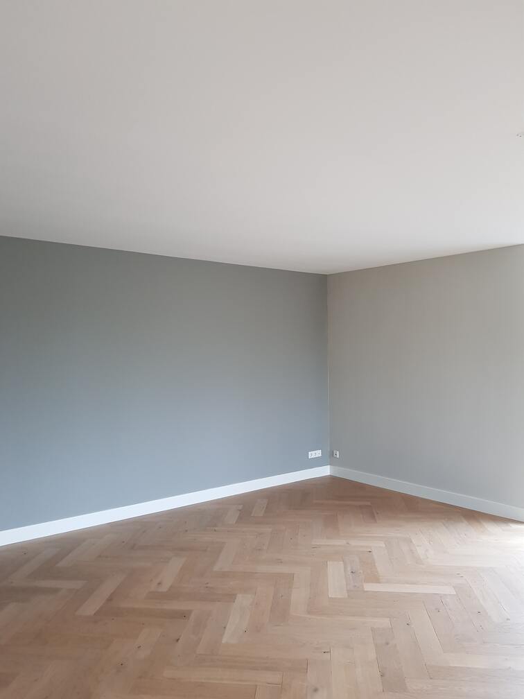 Deze foto toont een prachtig strak gestucte kamer, waarin de eenvoud en netheid van de muren een gevoel van ruimtelijkheid en frisheid creëren.